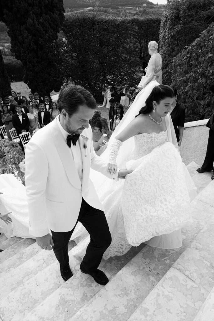 Bride and groom walking up the steps at Villa Rizzardi with their guests behind them